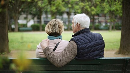 Couple de personnes âgées assis sur un banc.